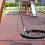 Single Swing (BNS 90cm) schommel met zwart netzitje en metalen kettingen op speelplaats.