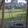 Single Swing (BNS 90cm) schommel met ronde netzitting en houten frame voor speelplaats.