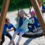 Single Swing (BNS 90cm) schommel met kinderen spelend op een zandondergrond.