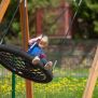 Single Swing (BNS 90cm) met zwart netzitschijf en houten frame op een speeltuin.